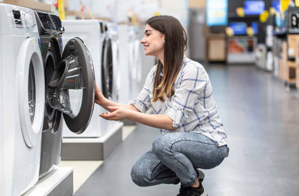 woman in a store chooses a washing machine