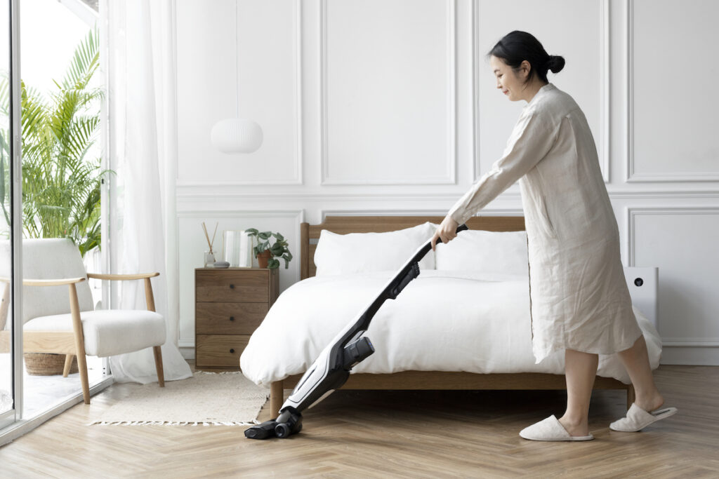 Woman vacuuming her bedroom