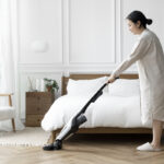 Woman vacuuming her bedroom